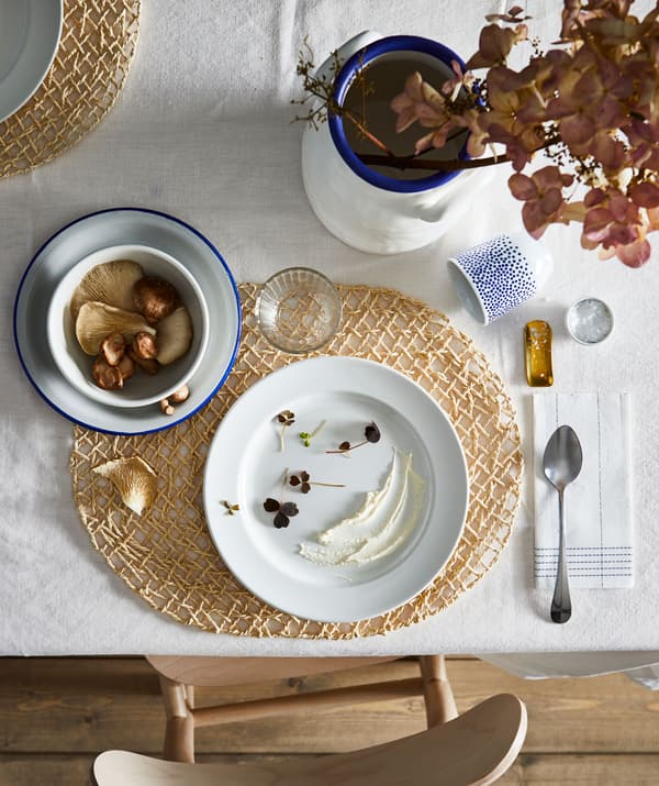 Sección dunha mesa de comedor cun bonito servizo para un, con cores, formas e decoracións combinadas.