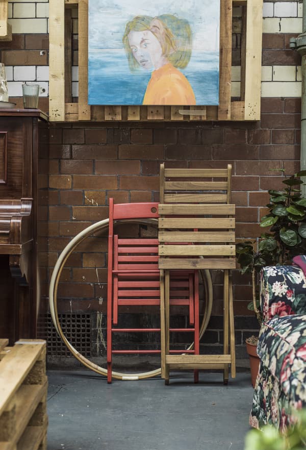 Sedie pieghevoli appoggiate a una parete piastrellata.