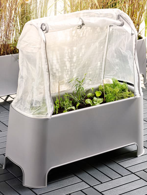 Šedý květináč s krytem ASPAREN na terase. 
