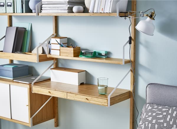 Séjour avec canapé et meuble mural en bambou, composé d'étagères et d'une tablette faisant office de bureau