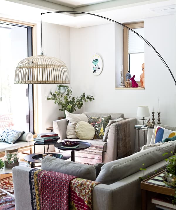 Séjour avec canapé, fauteuil et grand lampadaire.