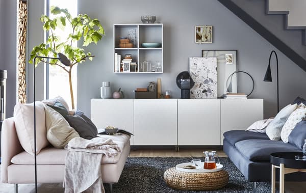 Séjour en gris et blanc avec meuble de rangement bas.