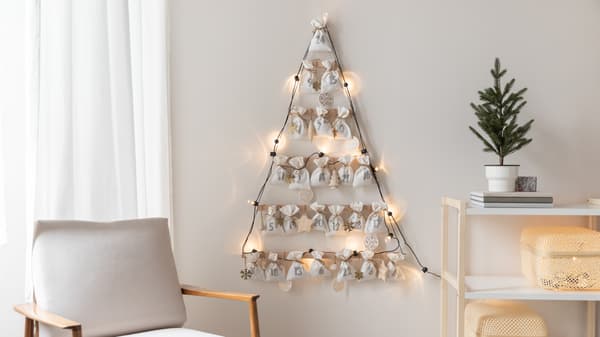 Selbstgenähter Adventskalender mit Säckchen an einer weißen Wand