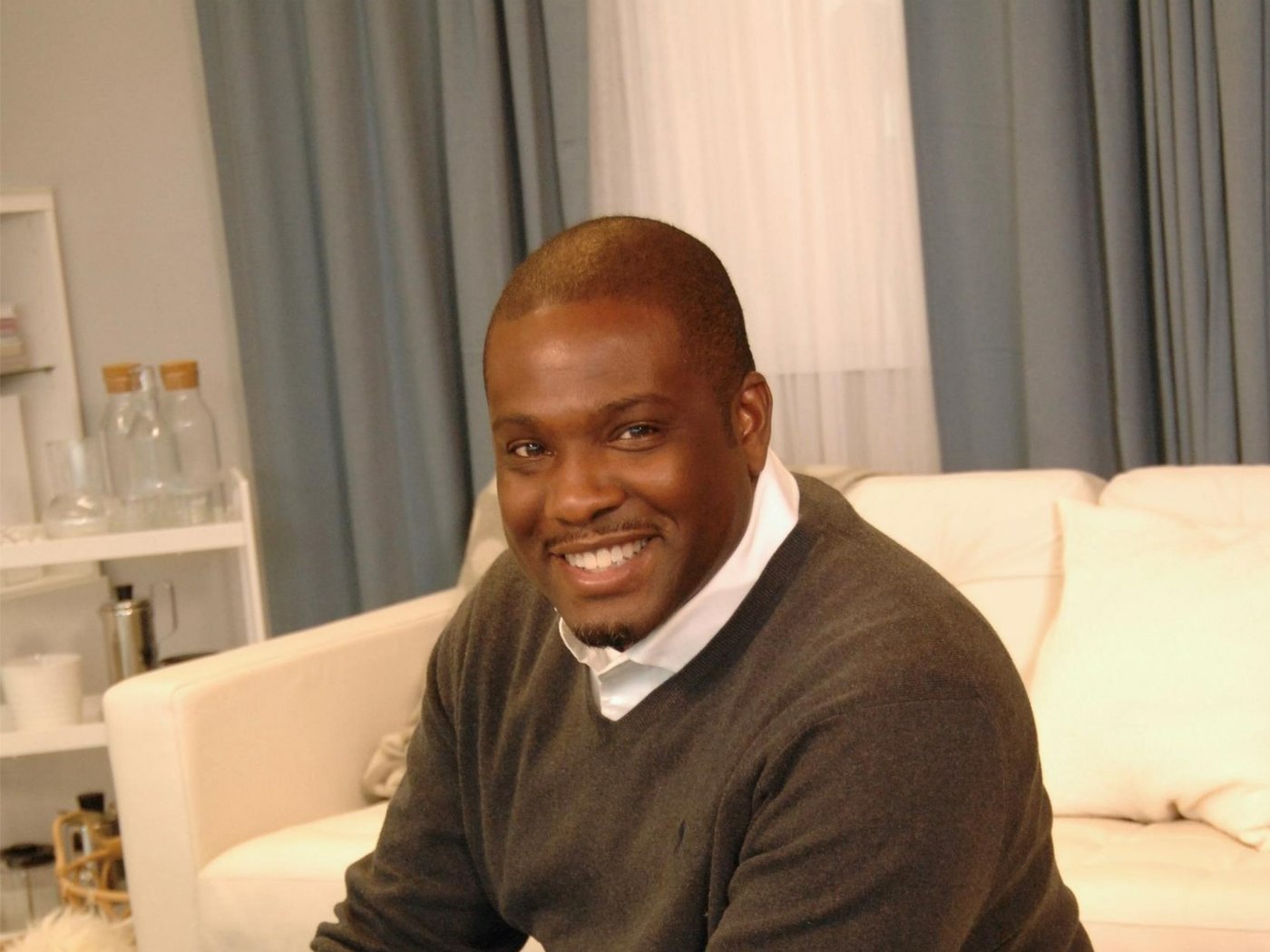 Selwyn Crittendon assis sur un pouf blanc