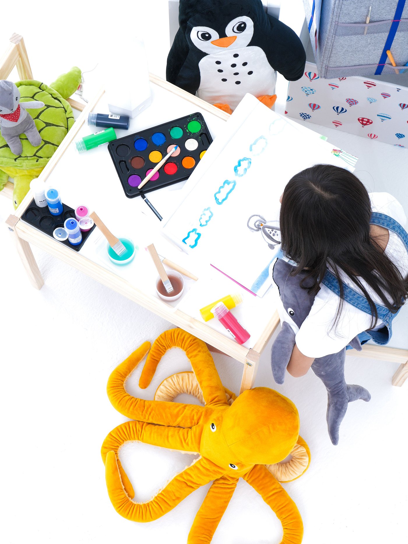 Seorang lelaki muda bermain dengan set kapal selam BLÅVINGAD pada ambal haiwan lautan BLÅVINGAD diperbuat daripada plastik sampah lautan.