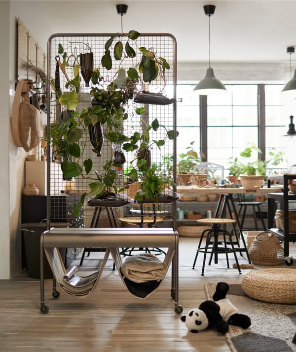 Separador d'espais IKEA VEBERÖD amb marc de malla d’acer que separa una sala d’una àrea de treball.