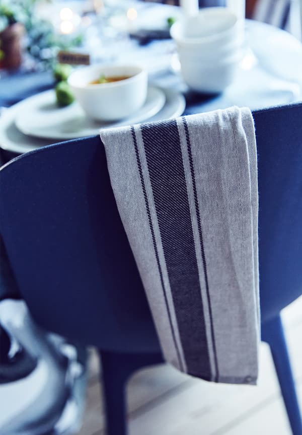 Serviette en lin sur une chaise IKEA bleue.