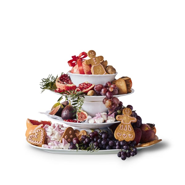 Serving dishes stacked with sweets and desserts on them. 