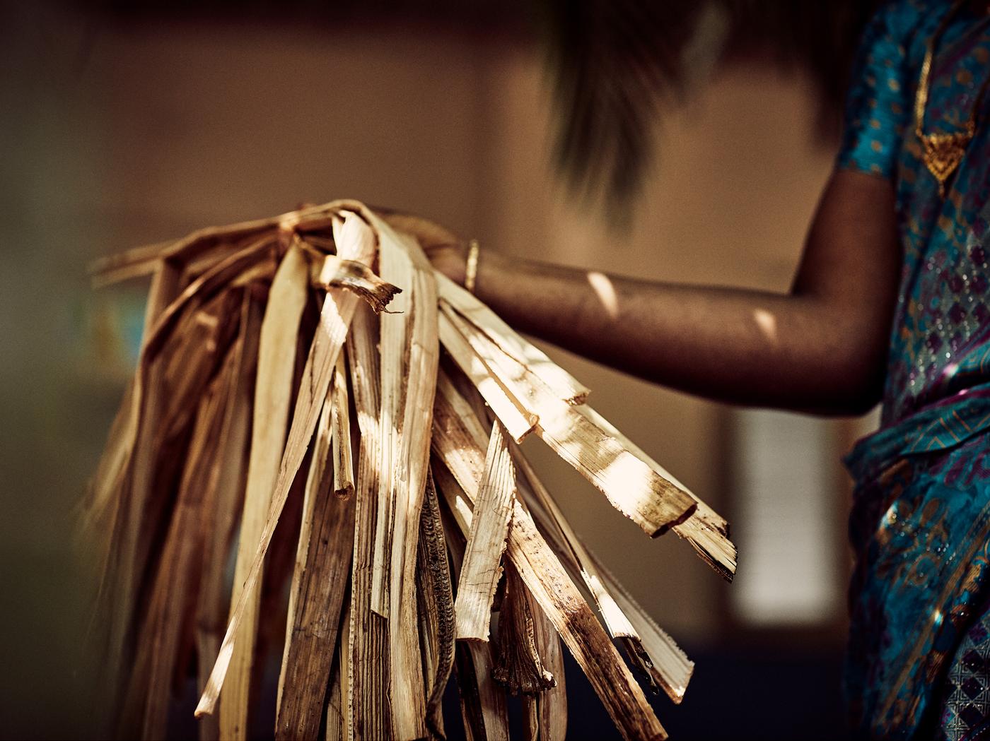 Seseorang sedang mengangkat seikat gentian pisang yang tahan lama, bahan boleh dibaharui semula jadi.