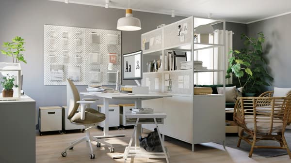 Set de muebles TROTTEN con escritorio de altura ajustable, una cajonera abierta y una silla con ruedas.