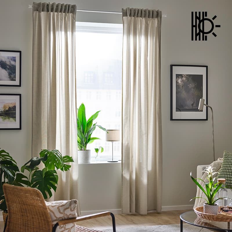 Set of beige/white dimming curtains hanging over windows in living room in Singapore