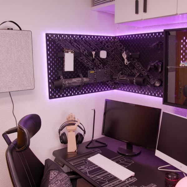 Set up de gaming con paneles perforados UPPSPEL de color negro, con el purificador FÖRNUFTIG y la silla de gaming GRUPPSPEL.