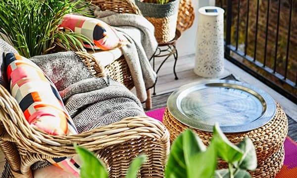 Set van meubels van rotan die staan op een balkon.
