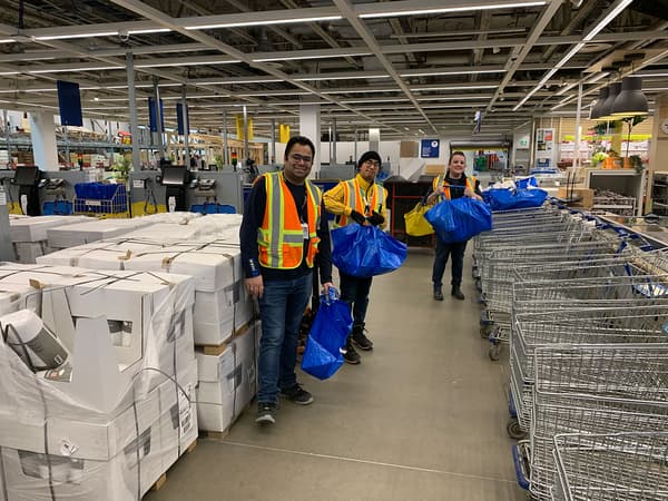 Several IKEA employees with donation bags.