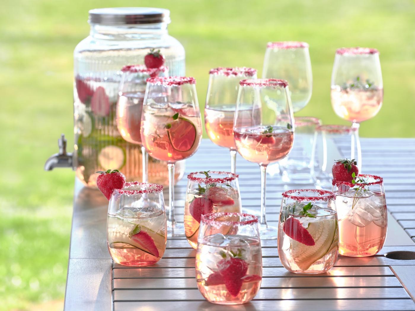 Several STORSINT wine glasses stending on the edge of a table top. 