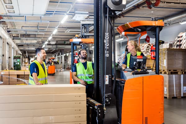 Several workers in a warehouse setting.