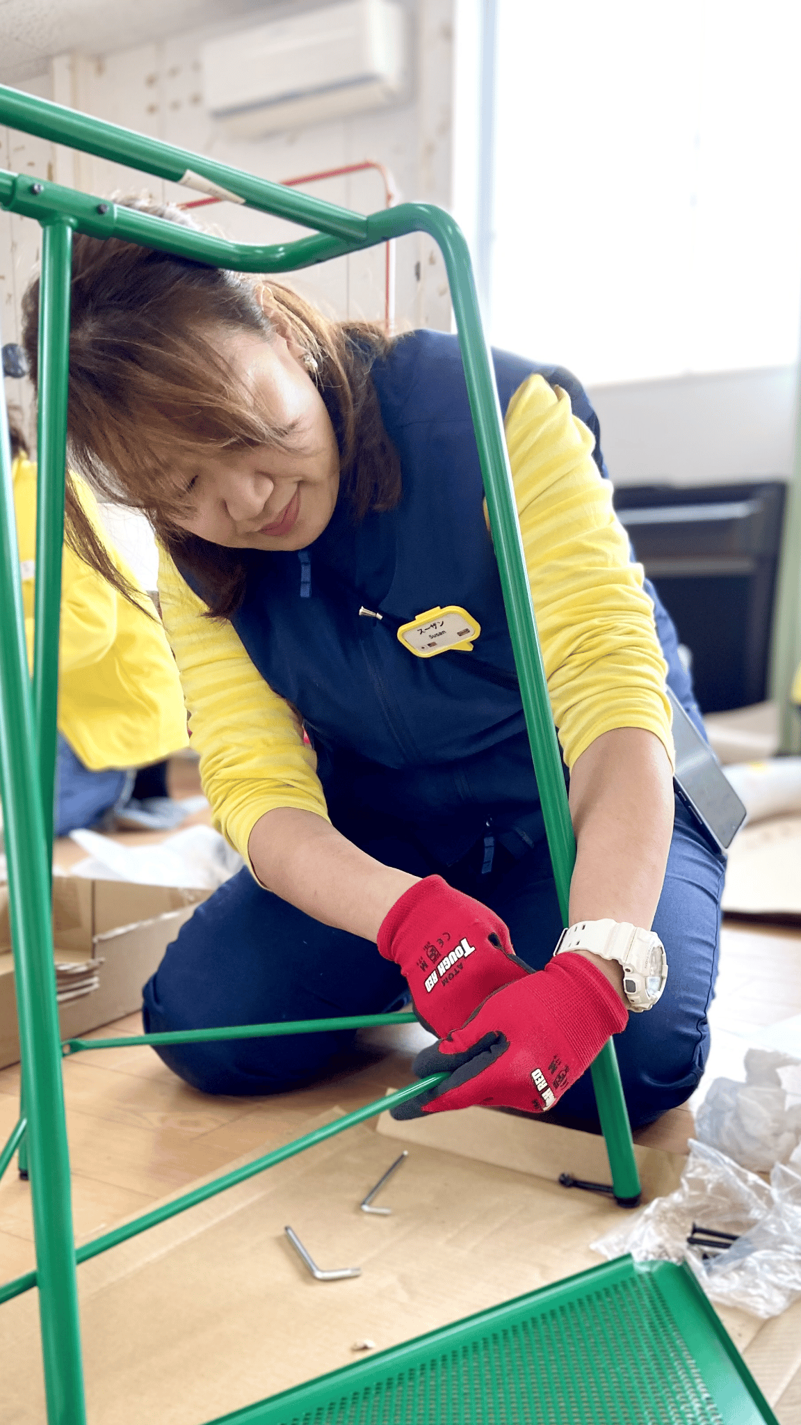 しゃがんで家具を組み立てるイケアスタッフ
