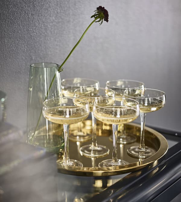 Shallow Champaign glasses on a GLATTIS tray in brass-coloured, metallised steel.