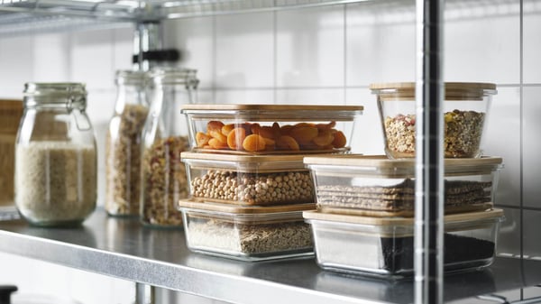 Shelves stocked with jars and containers filled with dried foods, grains, and pantry items in an organized kitchen.