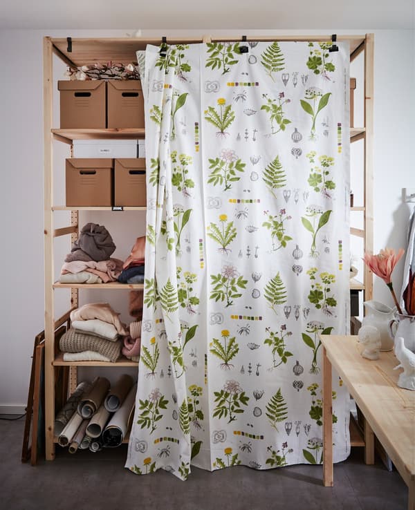 Shelving unit with a curtain.