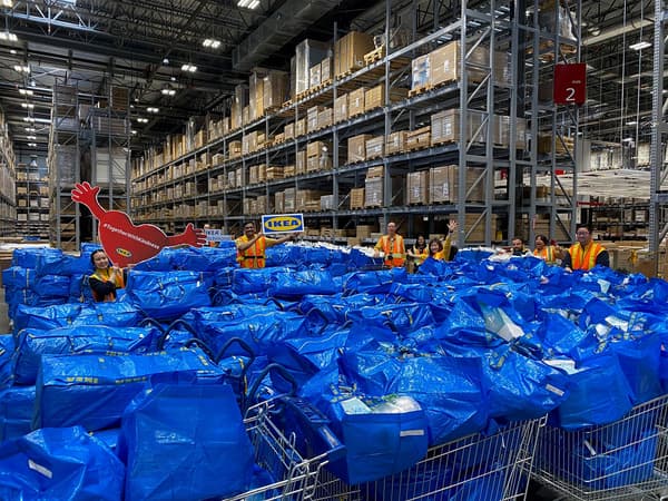 Shopping carts with blue IKEA bags filled with bedding.