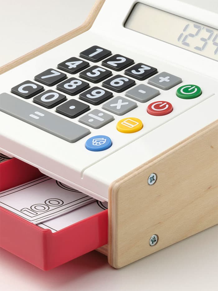 Side view of a DUKTIG cash register. The counter is opened to reveal fake coins and notes. 