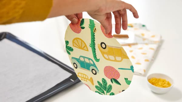 Sie hält das Bienenwachspapier in der Hand.