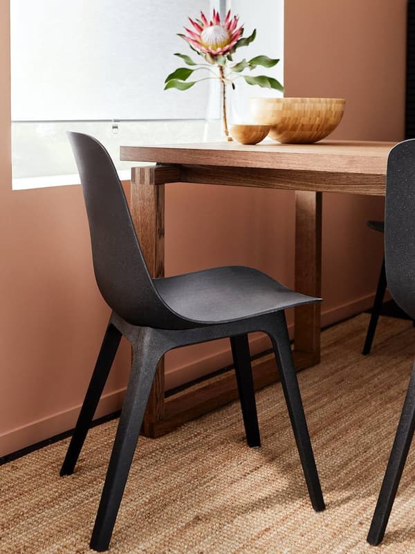 Silla ODGER color negro en un comedor, junto a una ventana.