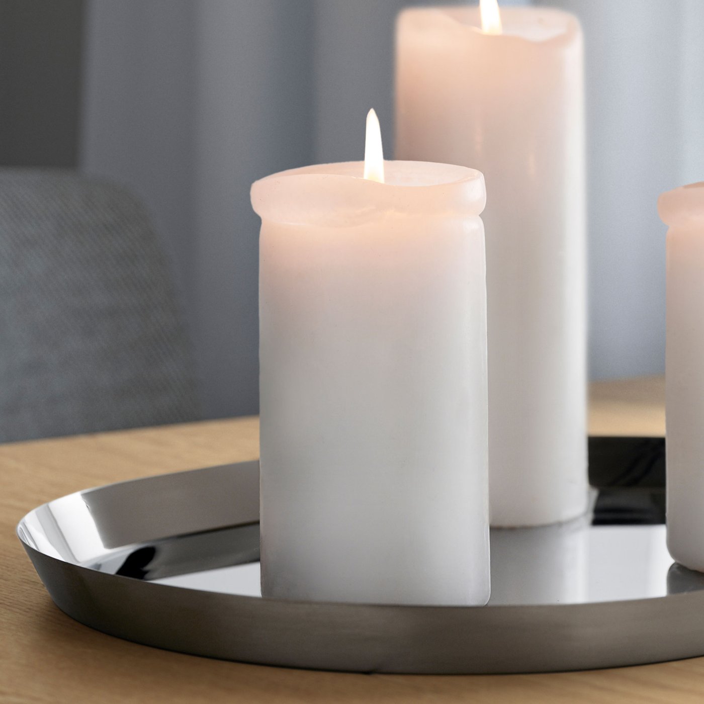 Silverfärgat ljusfat med tre vita blockljus. 