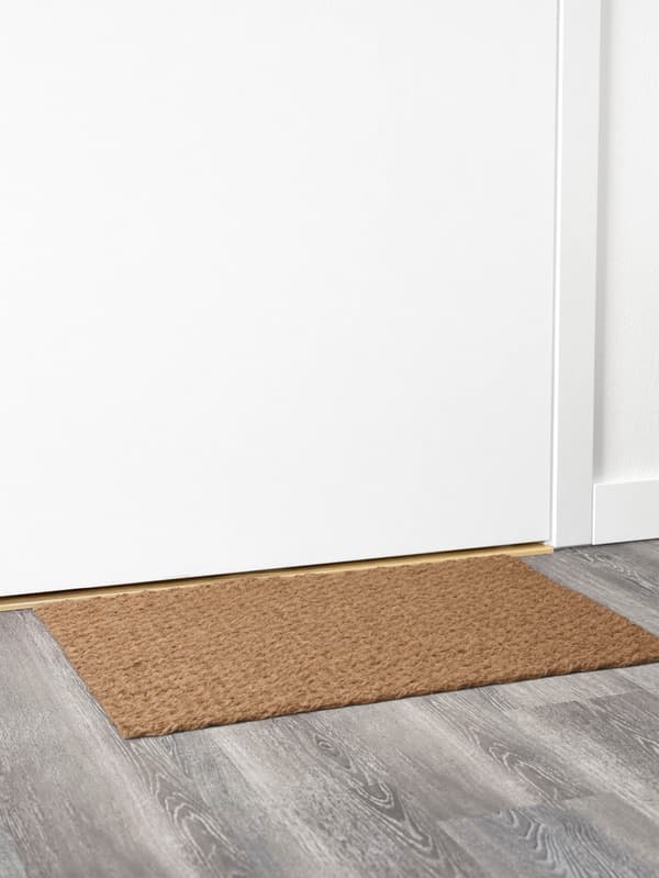 SINDAL lábtörlő a fehér ajtó előtt.