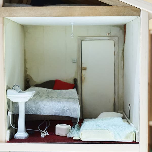 Sink with faulty electirc next to it. Mattress on the floor and a broken bed.