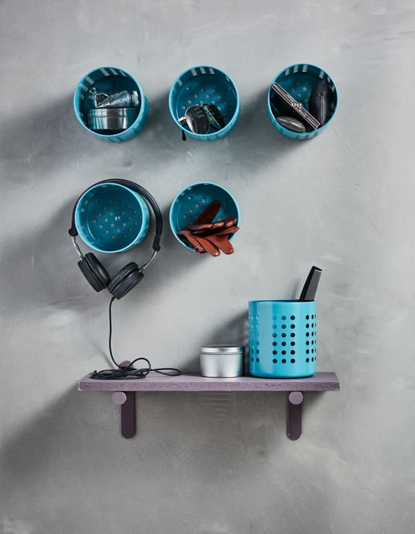 Six IKEA ORDNING utensil holders have been spray painted blue and are screwed to the wall to function as storage.