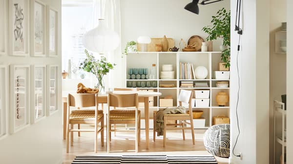 SKANSNÄS ronde, uittrekbare tafel in lichtgekleurd beuken/fineer en enkele SKANSNÄS stoelen in lichtgekleurd beuken staan onder een RISBYN hanglamp.