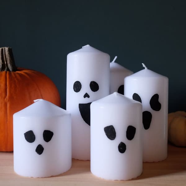 Skap en koselig atmosfære til Halloween med en liten spøkelsesfamilie. En for hvert familiemedlem. Alt du trenger er en svart sprittusj eller maling og hvite kubbelys.