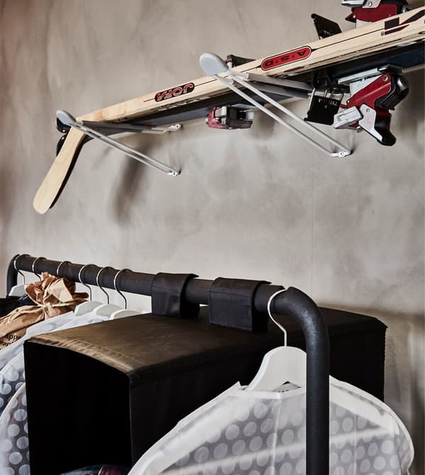 Skis and hockey sticks are stored on wall racks.