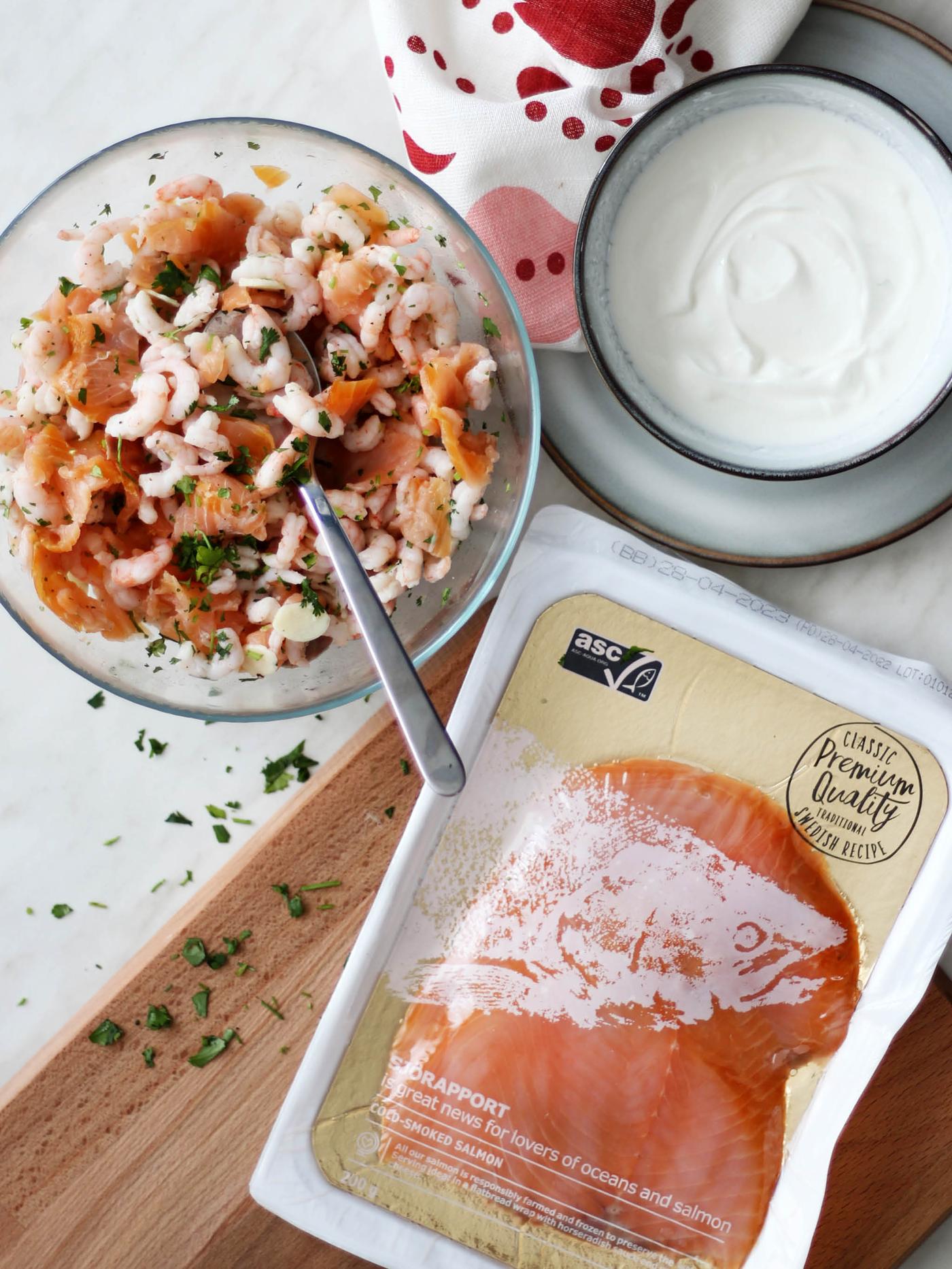 Skleněná mísa BLANDAleží vedle balení uzeného lososa SJÖRAPPORT a misky GLADELIG se zakysanou smetanou.