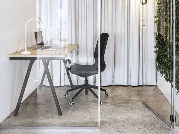 Skrivbord och svart skrivbordsstol i litet kontorsutrymme, 