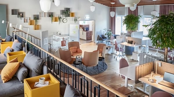 Skrivbordsplatser och fåtöljer i kontorslandskap