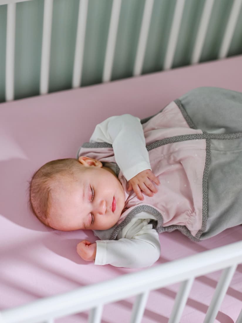 Sleep
Sleeping baby wrapped in a soft blanket, lying safely in a white crib.