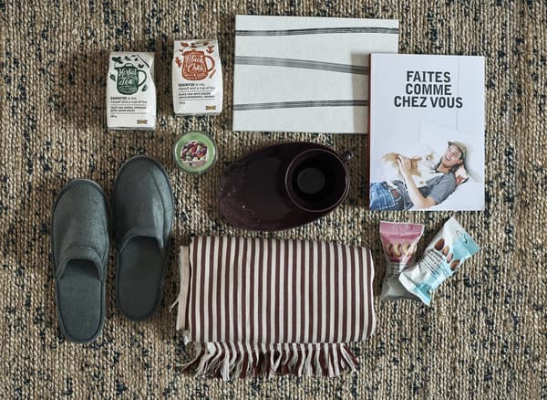 Slippers, books, homewares and snacks arranged on a rug.