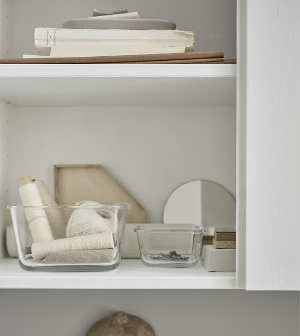 Small glass containers inside storage cabinets keep small items tidy and easy to find.