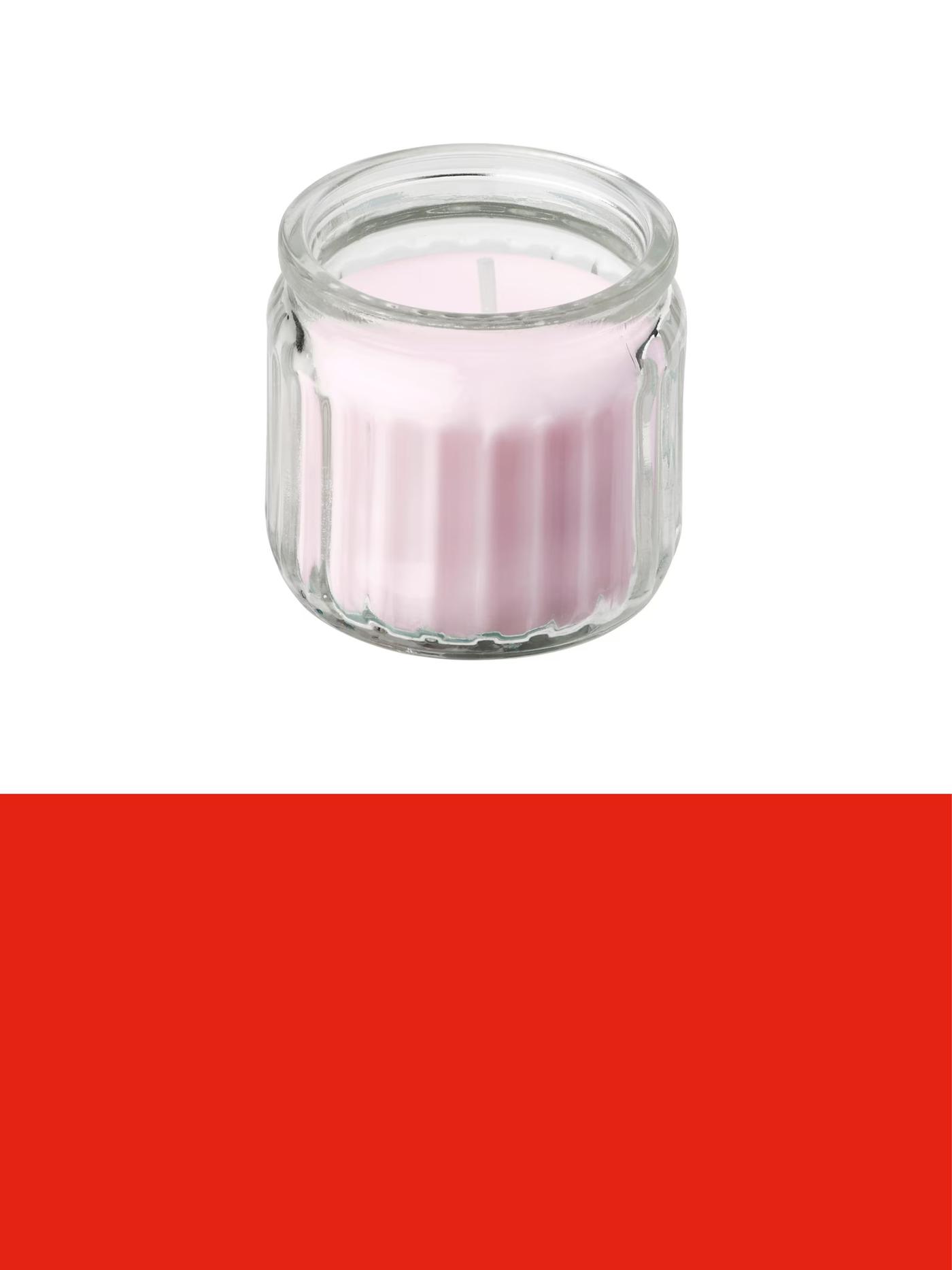 Small pink candle in a clear glass holder, displayed against a light background above a red promotional banner.