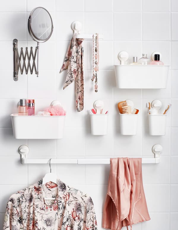 Small plastic baskets attached to the bathroom wall with suction cups, holding toiletries and accessories.