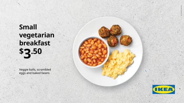 Small vegetarian breakfast. White plate on concrete background with scrambled egg, 4 veggie balls, and small bowl of baked beans, for $3.50