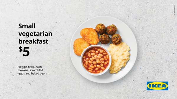 Small vegetarian breakfast. White plate on concrete background with scrambled egg, 4 veggie balls, and small bowl of baked beans