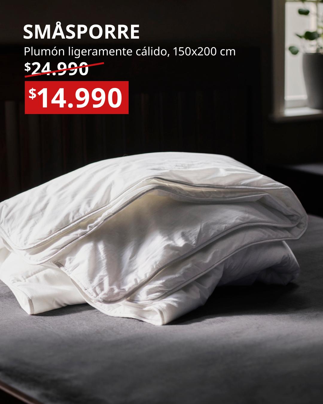 SMÅSPORRE plumón ligeramente cálido blanco 150x200 cm doblado sobre cama gris