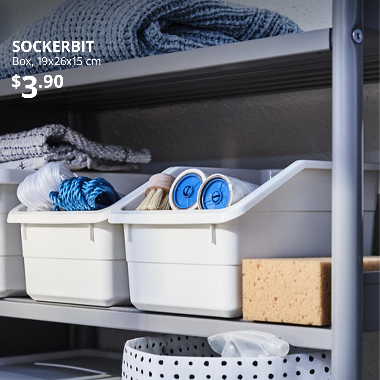 SOCKERBIT in white with home essentials like BÄSTIS lint rollers. Text on image reads "SOCKERBIT, Box, 19x26x15 cm. Price at $3.90."
