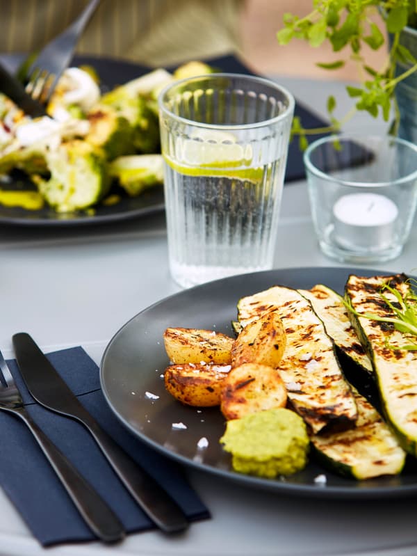 Sötétszürke FÄRGKLAR tálakon grillezett cukkini és sült burgonya.