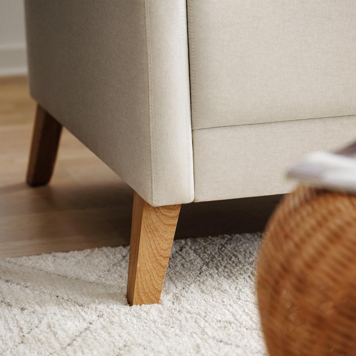 Sofá de la serie LINANÄS de color crema sobre una alfombra del mismo color.