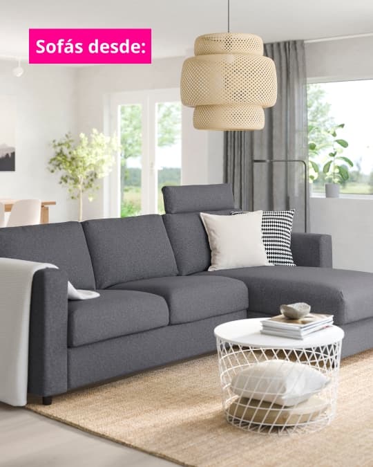 Sofá gris oscuro en una salita con alfombra beige.